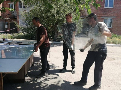 Павел Бережной помогает с установкой стеклопакетов в пострадавшем от атаки БПЛА многоквартирном доме в Миллеровском районе